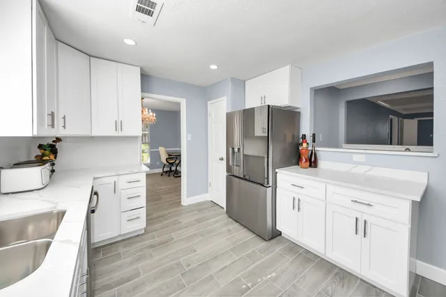 a kitchen with white cabinets and stainless steel appliances