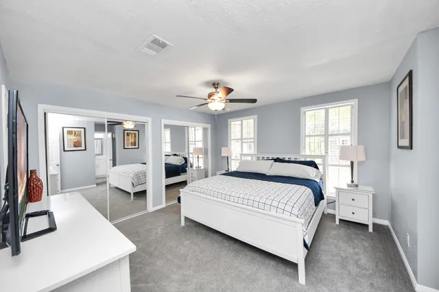 a spacious bedroom with a bed and a large mirror