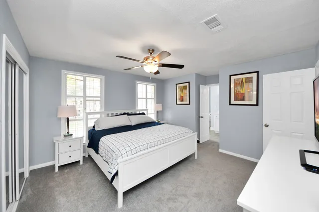 a bedroom with a large bed and a chandelier