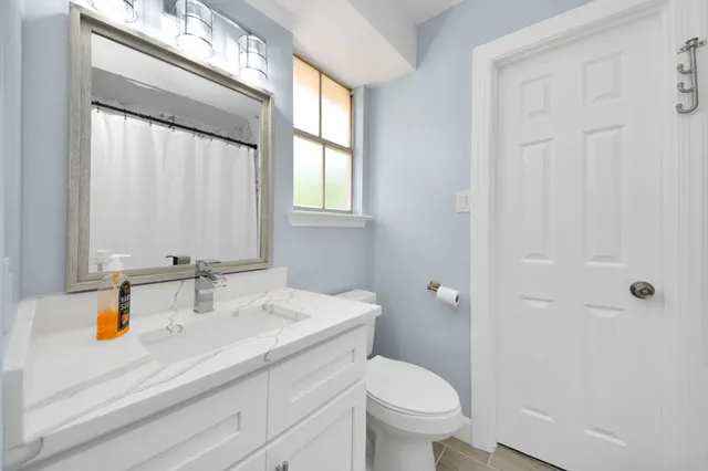 a bathroom with a sink a toilet and a window