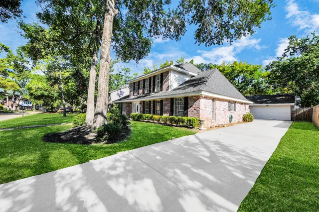 a front view of a house with a yard and potted plants