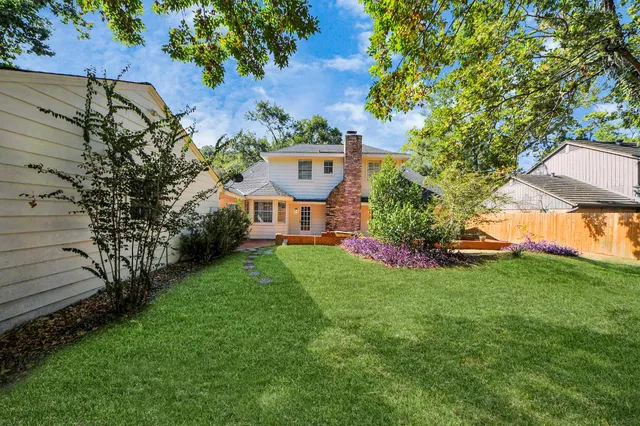 a green field with lots of trees in the background