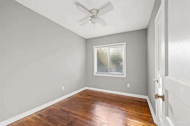 an empty room with a window and a ceiling fan