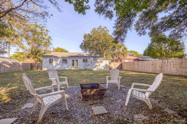 a view of a chairs and fire pit in the backyard