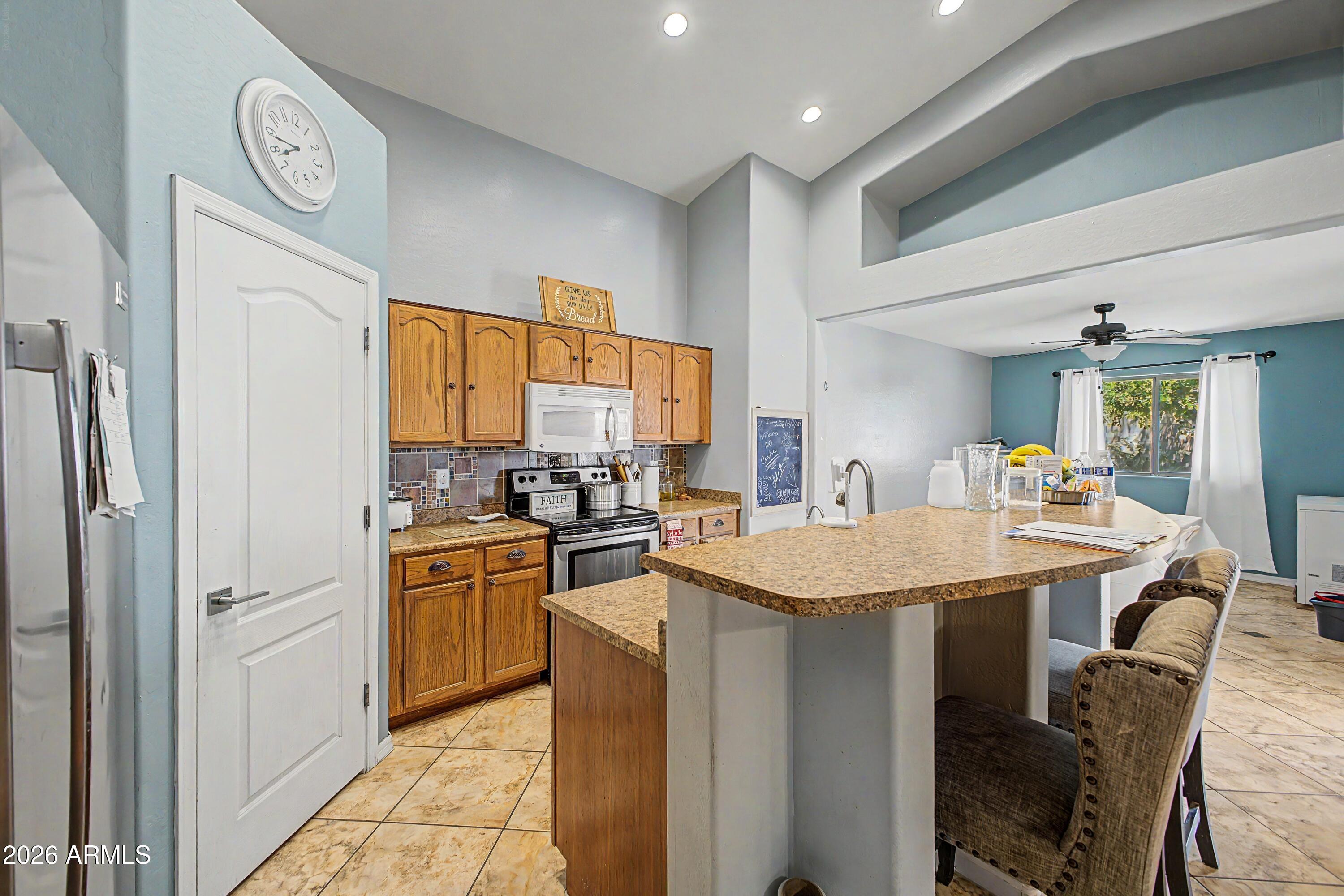 25652 West Rio Vista Lane Buckeye, AZ 85326 - Photo 15 of 32 a kitchen with stainless steel appliances granite countertop a sink stove and refrigerator
