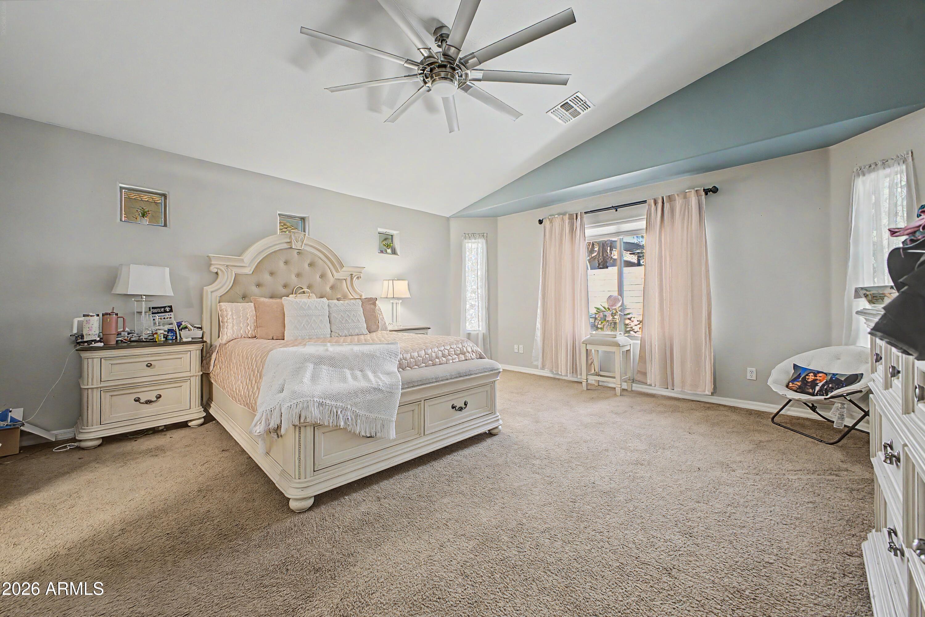 25652 West Rio Vista Lane Buckeye, AZ 85326 - Photo 17 of 32 a spacious bedroom with a bed and a chandelier