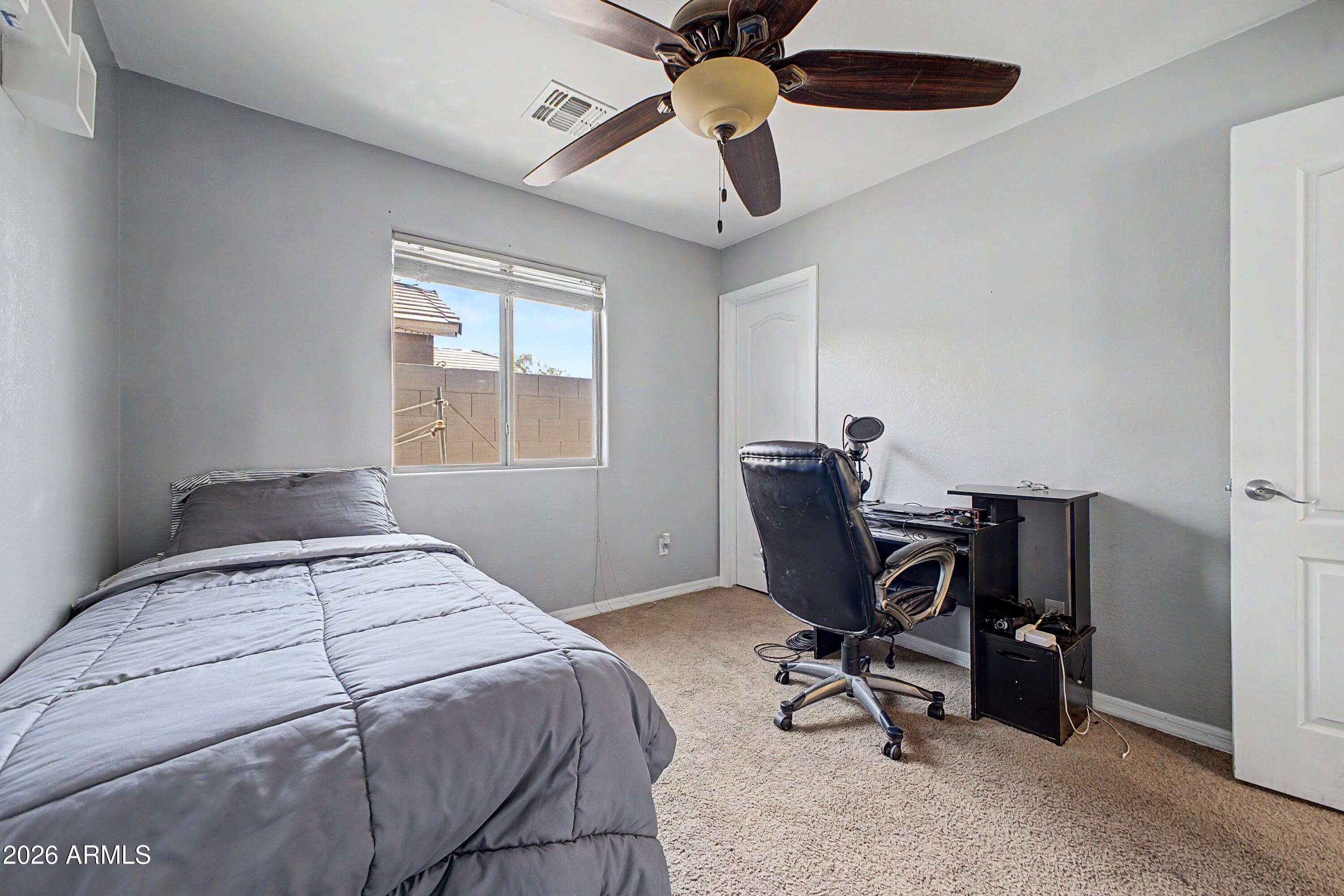 25652 West Rio Vista Lane Buckeye, AZ 85326 - Photo 25 of 32 a bedroom with a bed and a window