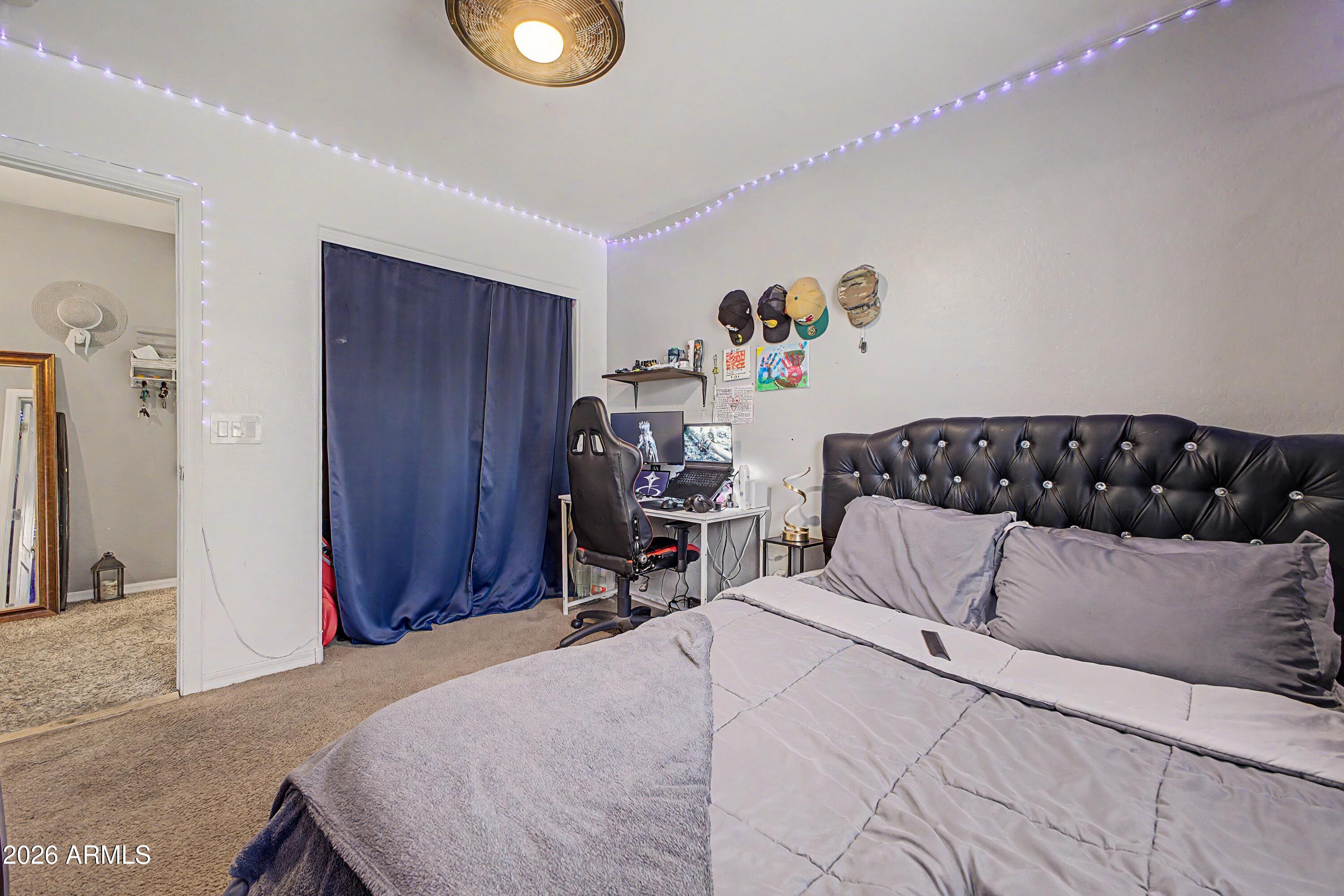 25652 West Rio Vista Lane Buckeye, AZ 85326 - Photo 27 of 32 a bedroom with a bed and wooden floor