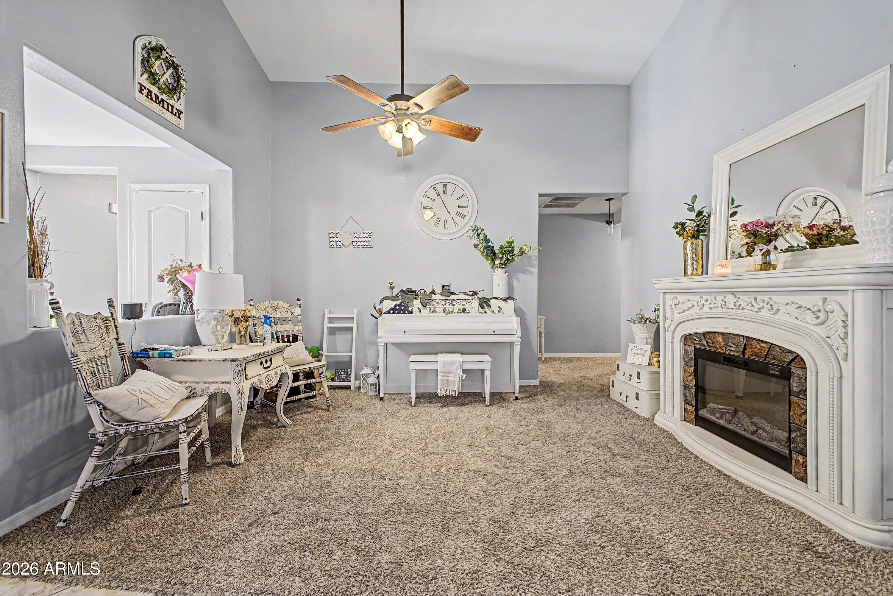 25652 West Rio Vista Lane Buckeye, AZ 85326 - Photo 6 of 32 a living room with a fireplace chandelier and a dining table