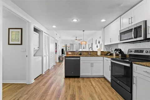a kitchen with stainless steel appliances granite countertop a refrigerator a stove top oven a sink and dishwasher