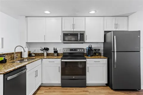 a kitchen with appliances a stove and cabinets