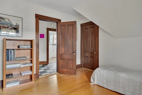 a bedroom with a bed and wooden floor