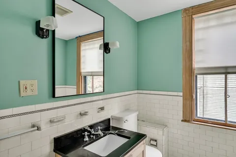 a front view of a house with a yard and potted plants