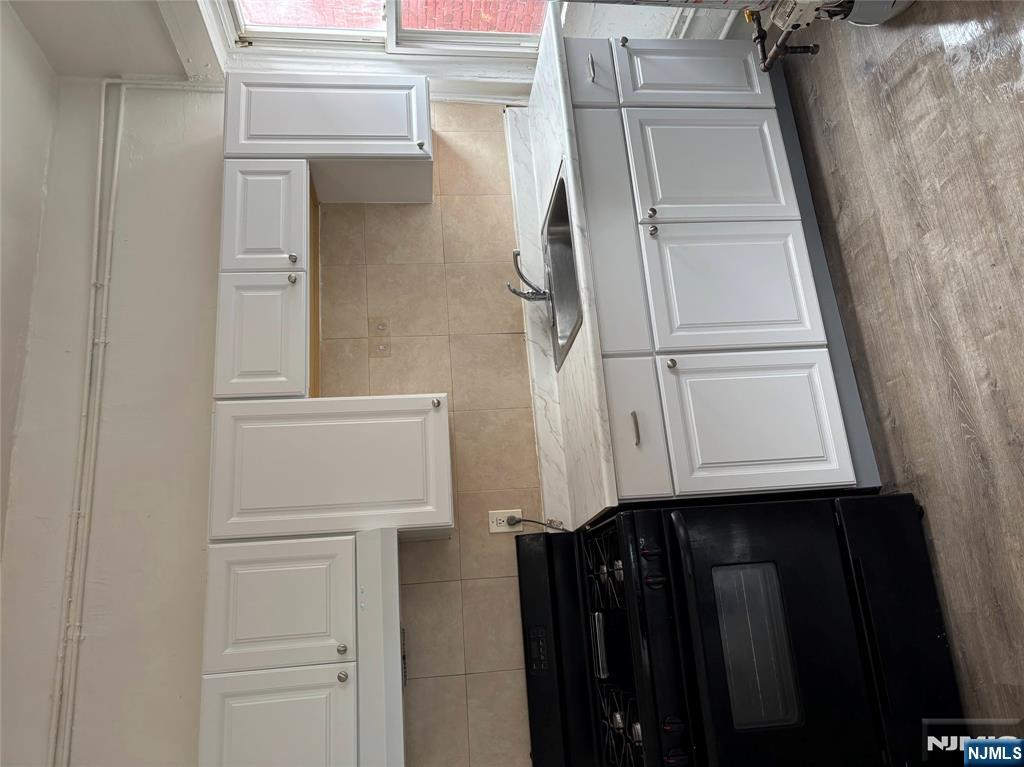 28 Fair Street, Unit 28B Hackensack, NJ 07601 - Photo 2 of 8 a kitchen with granite countertop white cabinets and black appliances