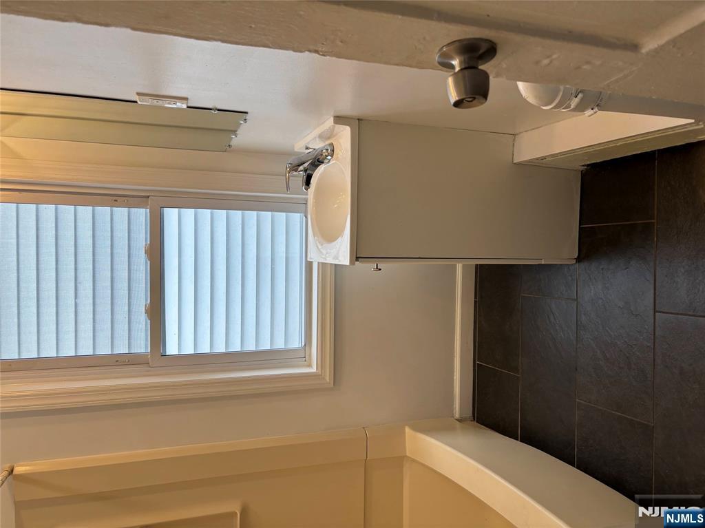 28 Fair Street, Unit 28B Hackensack, NJ 07601 - Photo 7 of 8 a bathroom with a sink and a bath tub