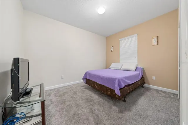 a spacious bedroom with a bed and a flat screen tv