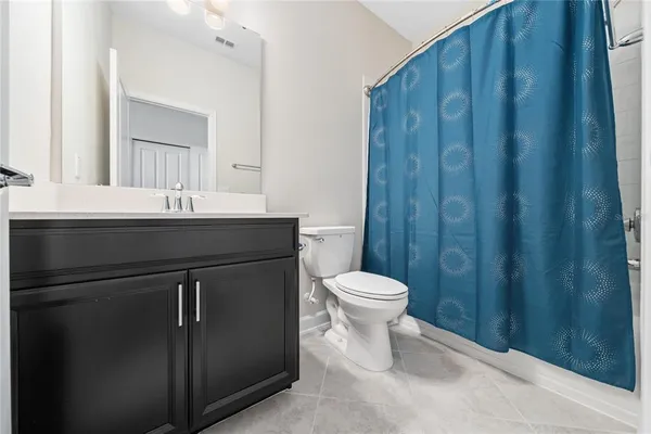 a bathroom with a sink a toilet a mirror and shower curtain