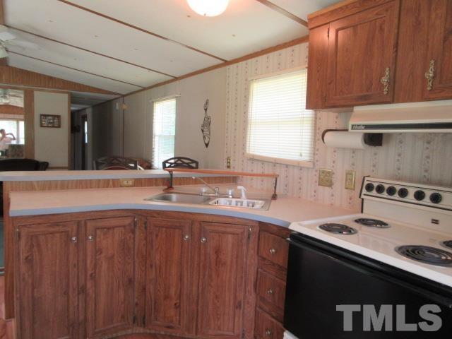 9565 George Ruff Road Bullock, NC 27507 - Photo 6 of 15 a kitchen with stainless steel appliances a sink dishwasher stove and cabinets