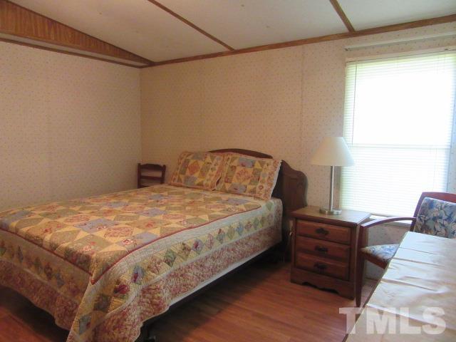9565 George Ruff Road Bullock, NC 27507 - Photo 8 of 15 a bedroom with a bed and wooden floor