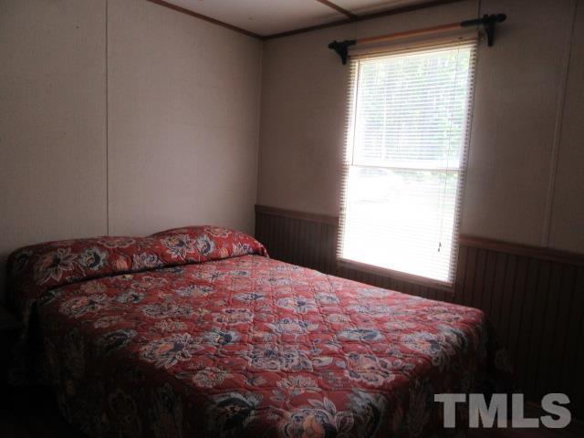 9565 George Ruff Road Bullock, NC 27507 - Photo 9 of 15 a bed sitting in a bedroom next to a window
