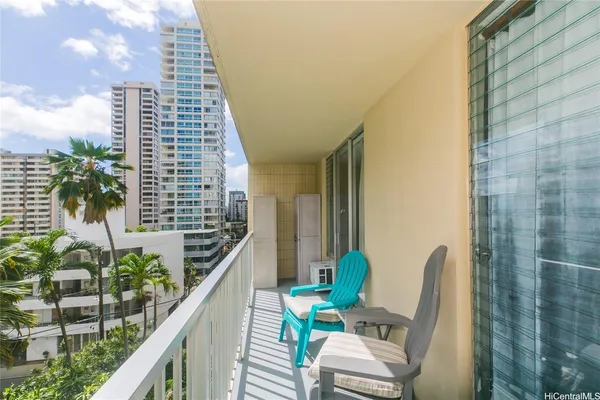 a balcony with chairs and a potted plant