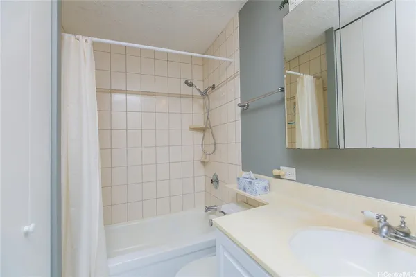 a bathroom with a granite countertop sink and a bathtub