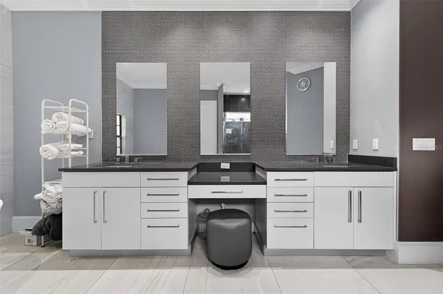 a dining room with stainless steel appliances kitchen island granite countertop a table chairs and a refrigerator