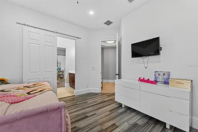 a living room with baby crib and a book shelf