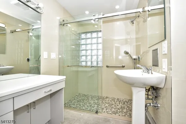 a bathroom with a sink a mirror and a shower