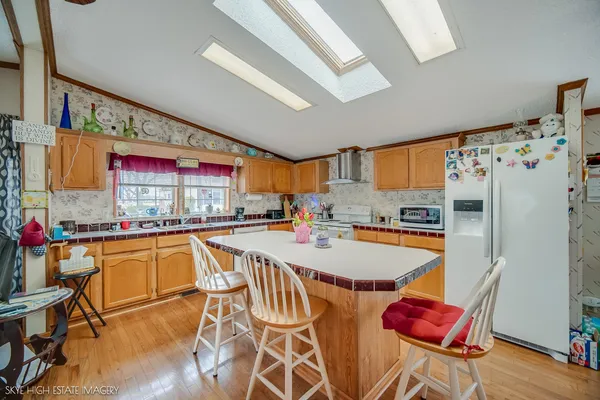 a kitchen with stainless steel appliances granite countertop a dining table chairs sink and cabinets