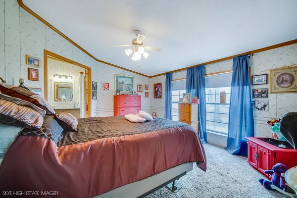 a bedroom with a large bed and a chandelier