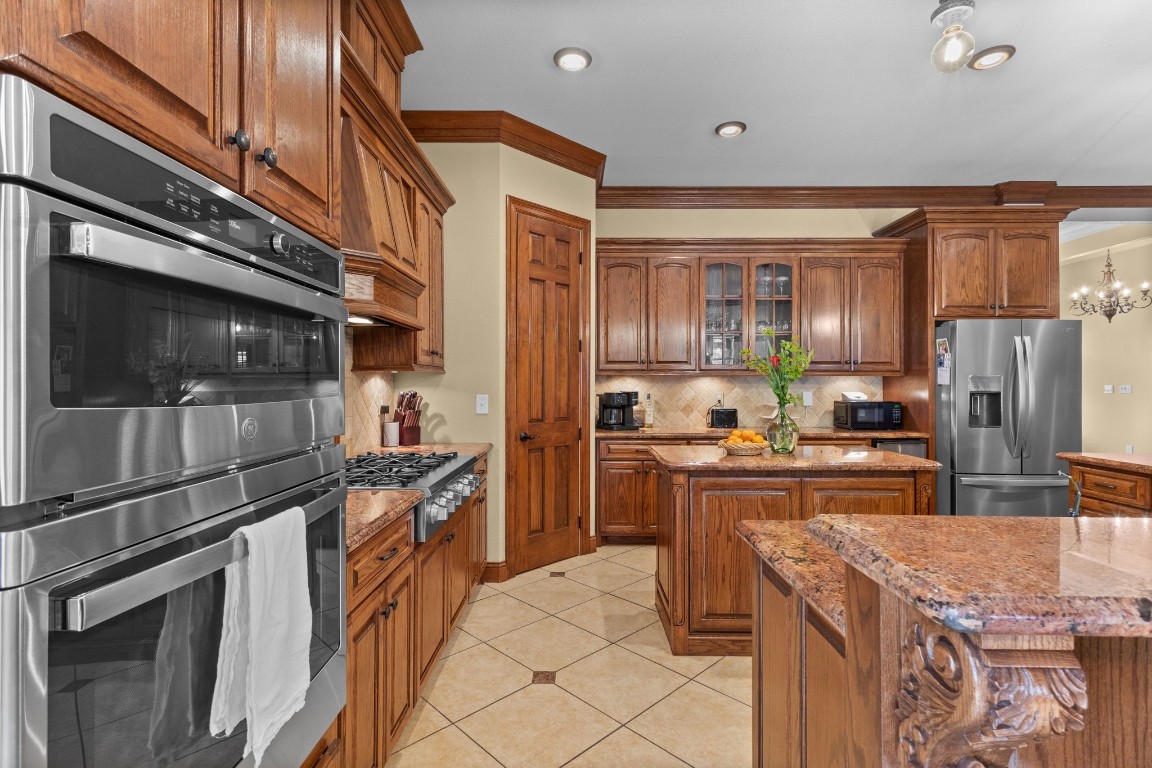 5535 Bearfoot Road Orange, TX 77632 - Photo 12 of 50 a kitchen with stainless steel appliances granite countertop a refrigerator a stove and a sink with wooden floor