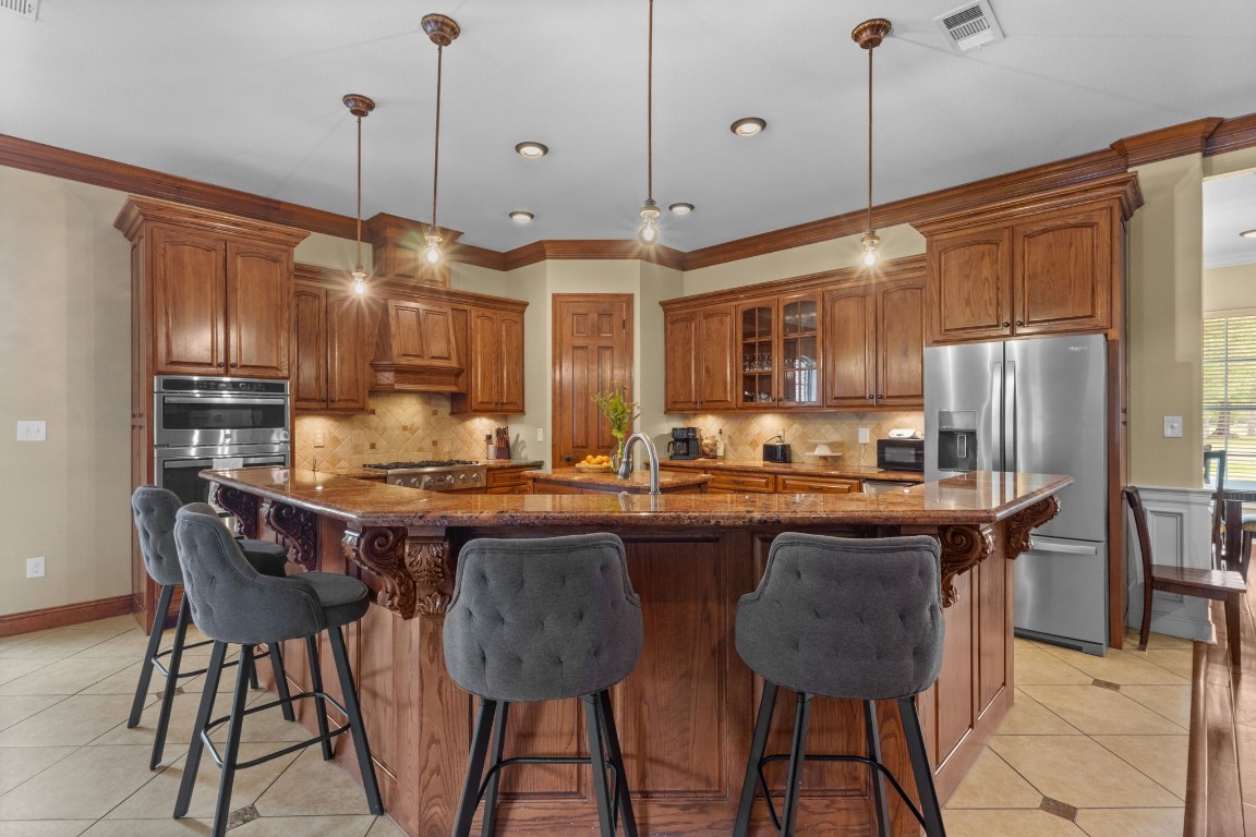5535 Bearfoot Road Orange, TX 77632 - Photo 16 of 50 a kitchen with stainless steel appliances granite countertop a stove a refrigerator a oven a sink with a dining table and chairs