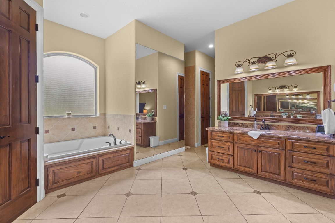 5535 Bearfoot Road Orange, TX 77632 - Photo 22 of 50 a bathroom with a tub a sink and a mirror