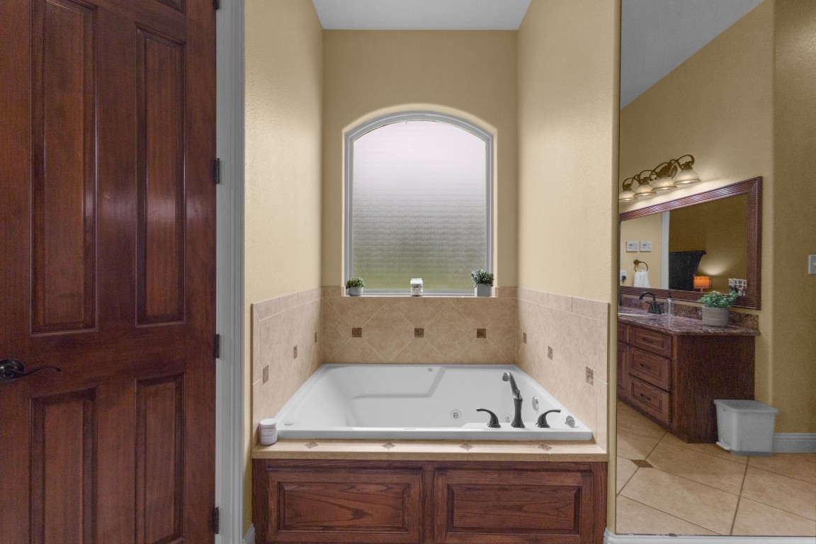5535 Bearfoot Road Orange, TX 77632 - Photo 23 of 50 a bathroom with a tub a sink and mirrors