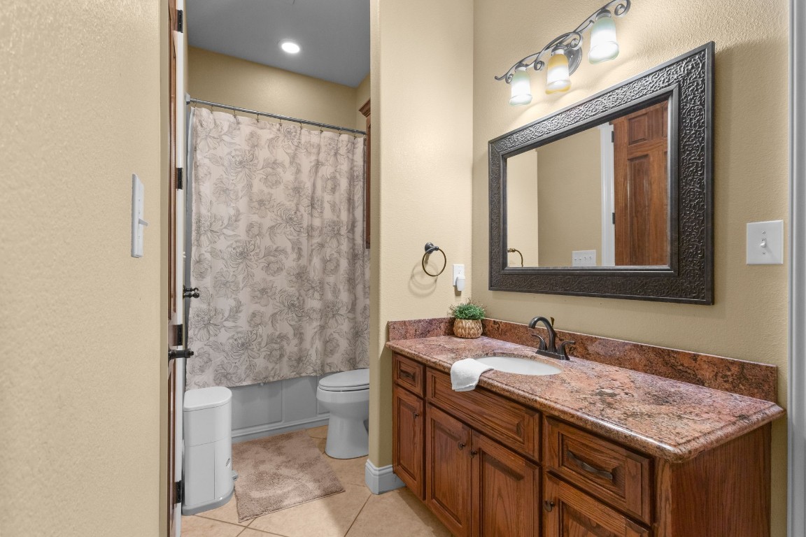 5535 Bearfoot Road Orange, TX 77632 - Photo 27 of 50 a bathroom with a granite countertop sink toilet and shower