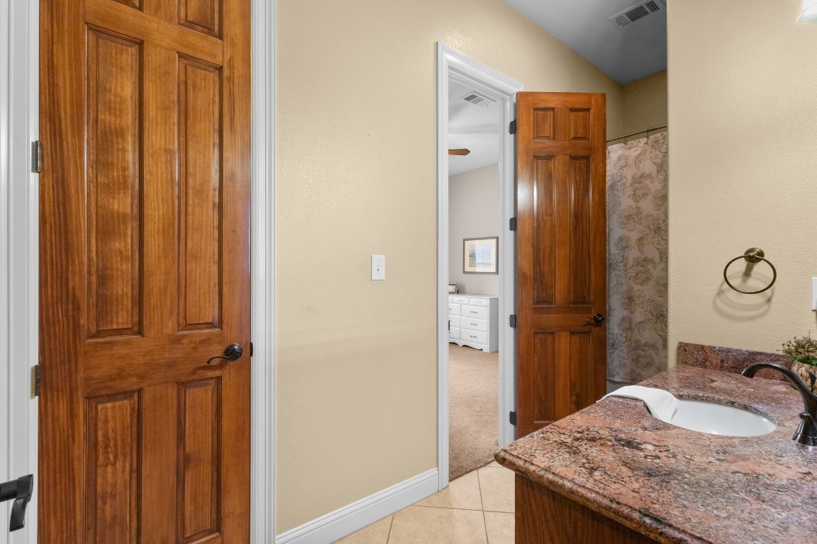 5535 Bearfoot Road Orange, TX 77632 - Photo 28 of 50 a bathroom with a granite countertop sink and a mirror