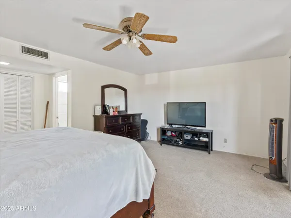 a bedroom with a bed and a mirror on dresser