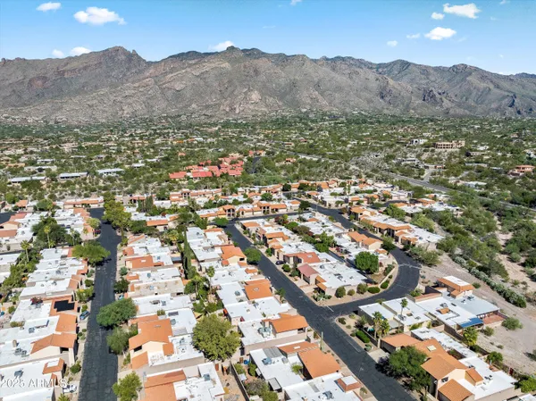 an aerial view of residential houses with outdoor space and trees