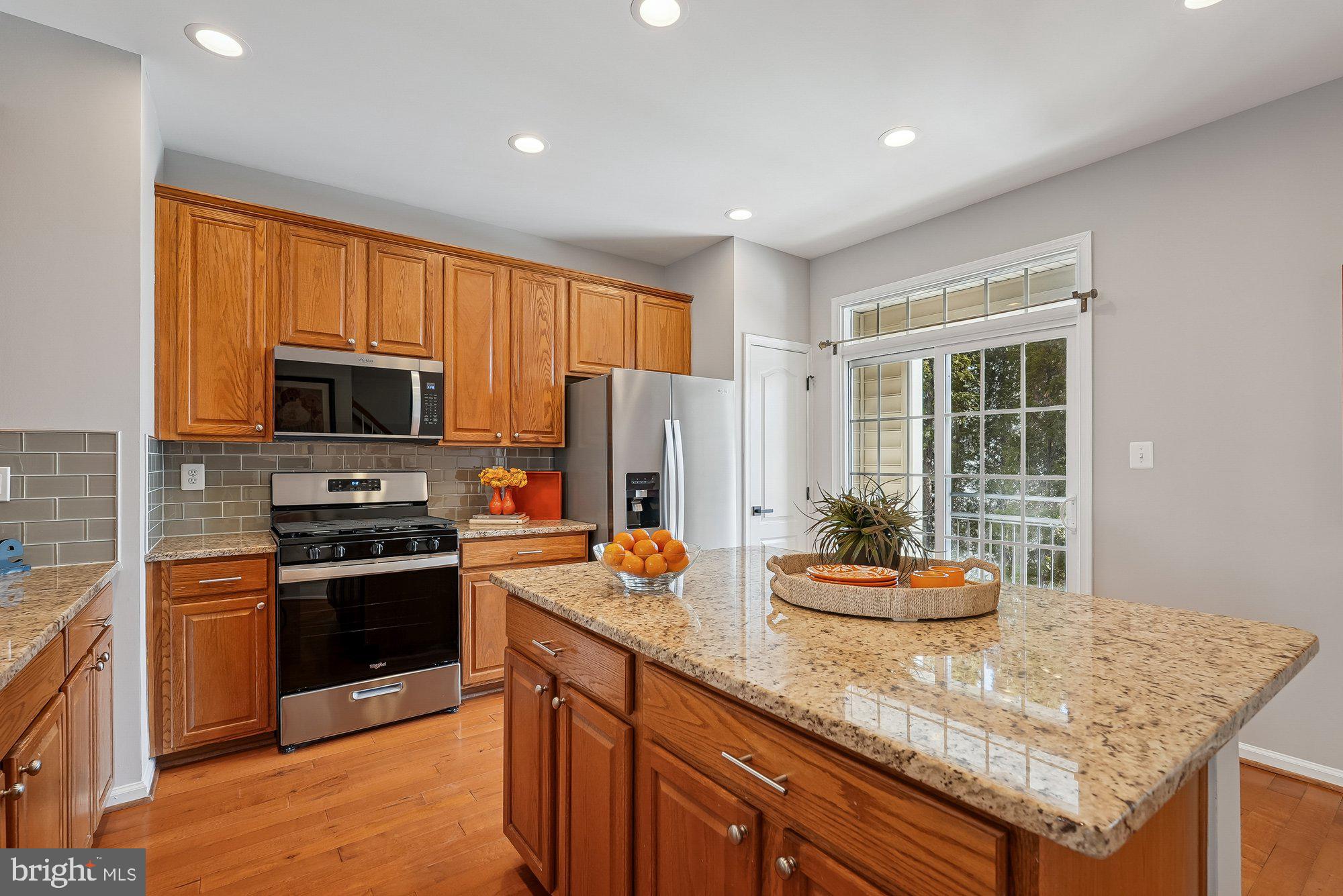 22982 Fox Fire Terrace Brambleton, VA 20148 - Photo 23 of 50 a kitchen with stainless steel appliances granite countertop a stove refrigerator sink and microwave