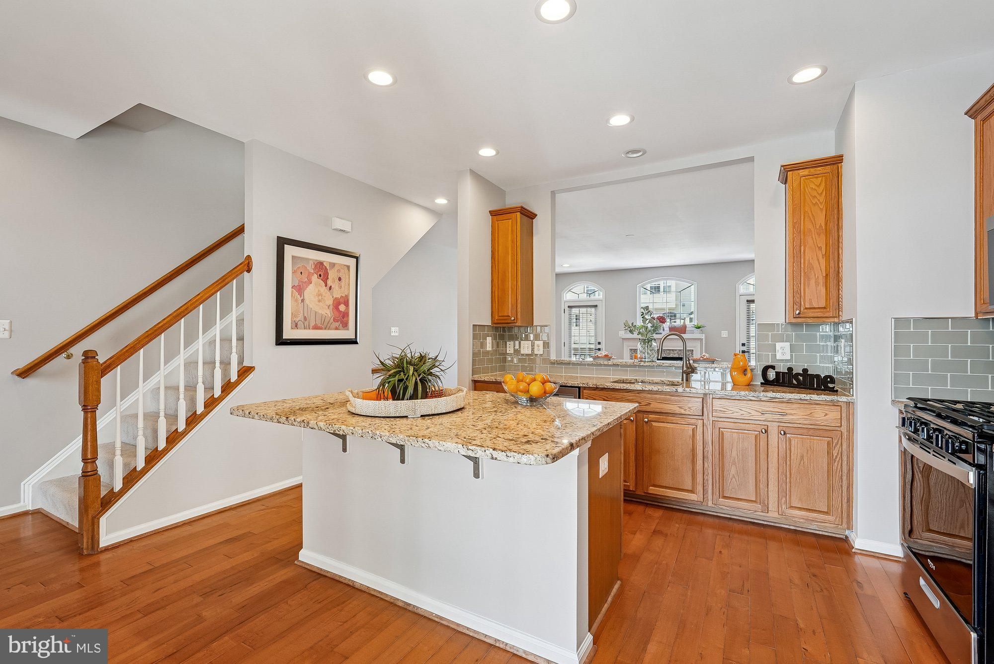 22982 Fox Fire Terrace Brambleton, VA 20148 - Photo 25 of 50 a kitchen with stainless steel appliances granite countertop a sink cabinets and wooden floor