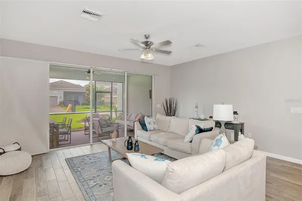 a living room with furniture kitchen view and a chandelier