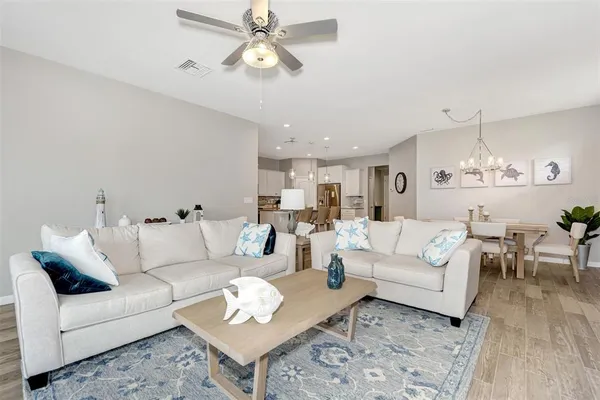 a view of a dining room with furniture a chandelier and wooden floor