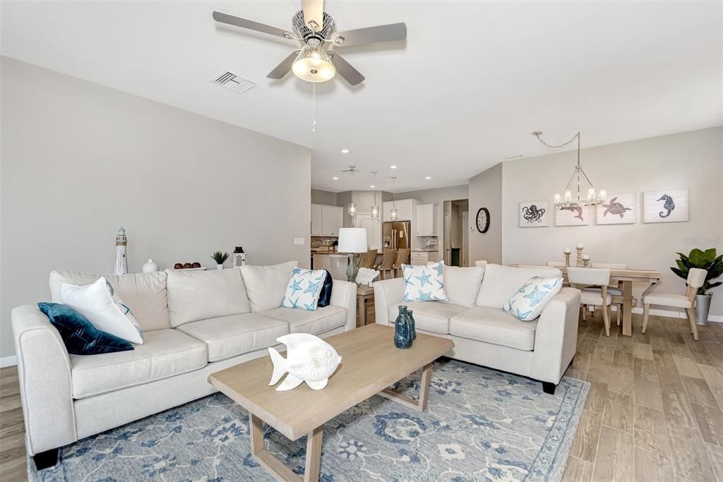 11616 Golden Bay Place Lakewood Ranch, FL 34211 - Photo 13 of 66 a living room with furniture kitchen view and a chandelier