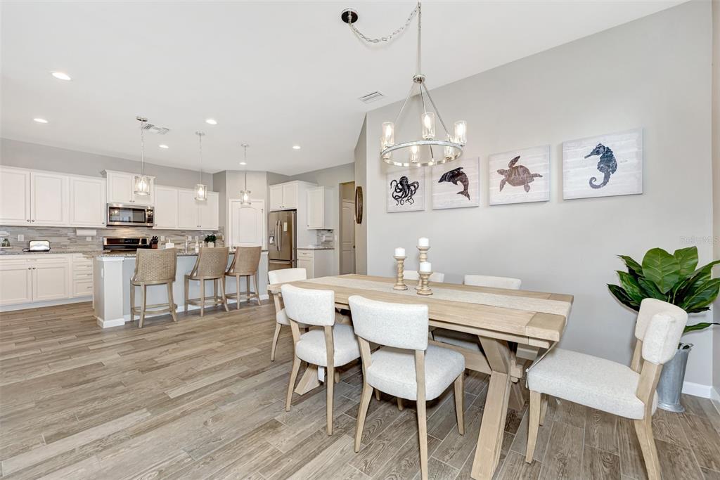11616 Golden Bay Place Lakewood Ranch, FL 34211 - Photo 15 of 66 a view of a dining room with furniture and wooden floor