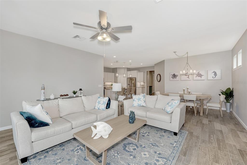 11616 Golden Bay Place Lakewood Ranch, FL 34211 - Photo 16 of 66 a living room with furniture and a chandelier