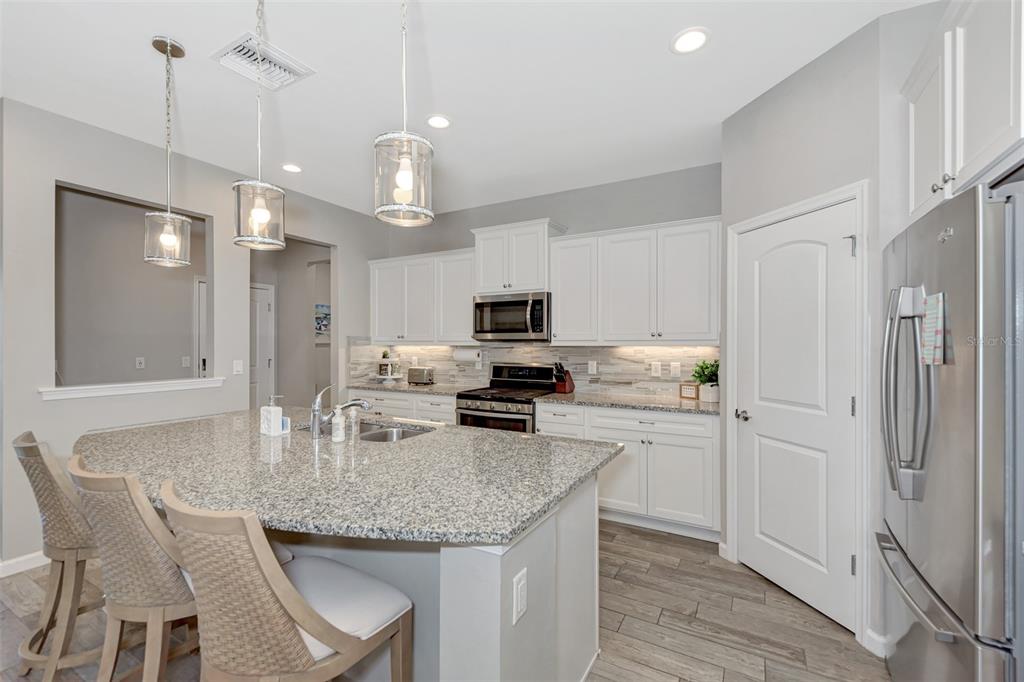 11616 Golden Bay Place Lakewood Ranch, FL 34211 - Photo 19 of 66 a kitchen with stainless steel appliances granite countertop a sink refrigerator and cabinets