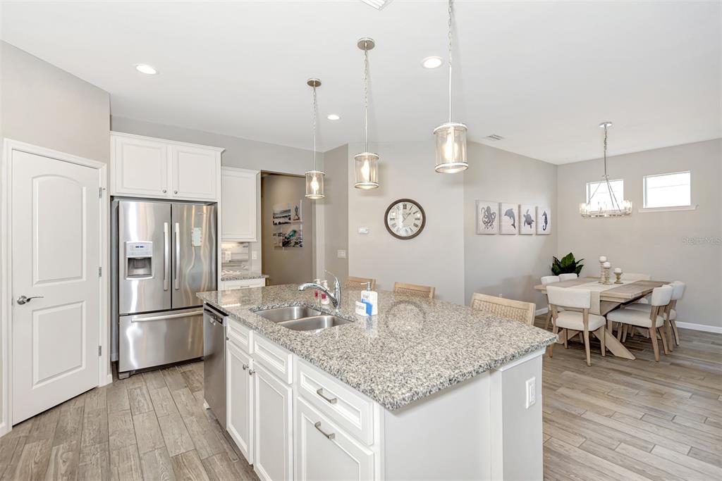 11616 Golden Bay Place Lakewood Ranch, FL 34211 - Photo 23 of 66 a kitchen with stainless steel appliances granite countertop a kitchen island hardwood floor and a sink