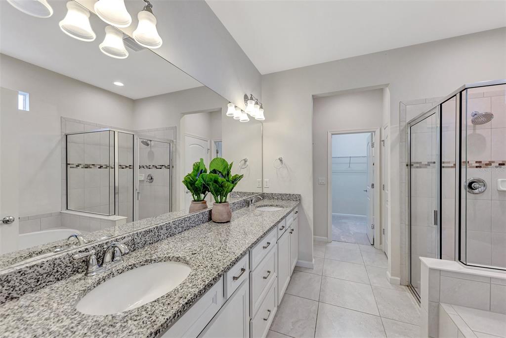 11616 Golden Bay Place Lakewood Ranch, FL 34211 - Photo 29 of 66 a bathroom with a granite countertop sink a large mirror and a shower