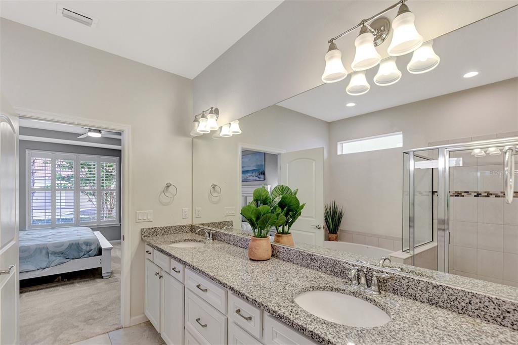 11616 Golden Bay Place Lakewood Ranch, FL 34211 - Photo 31 of 66 a spacious bathroom with a granite countertop sink a large mirror and a shower